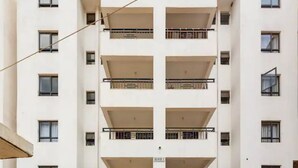 Un immeuble résidentiel à plusieurs étages, doté de balcons, avec une enseigne indiquant « BLOC 2 », et offrant une vue dégagée sur la façade du bâtiment.