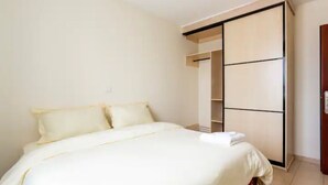 A bedroom with a bed, a wardrobe, and a door. - Lovely private room with free parking on premises (Nairobi)