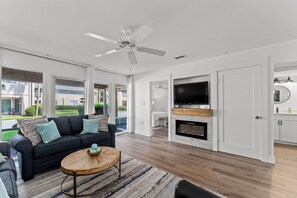 Relax in this stylish living room with a sofa, coffee table, and large windows offering a view of the outside.
