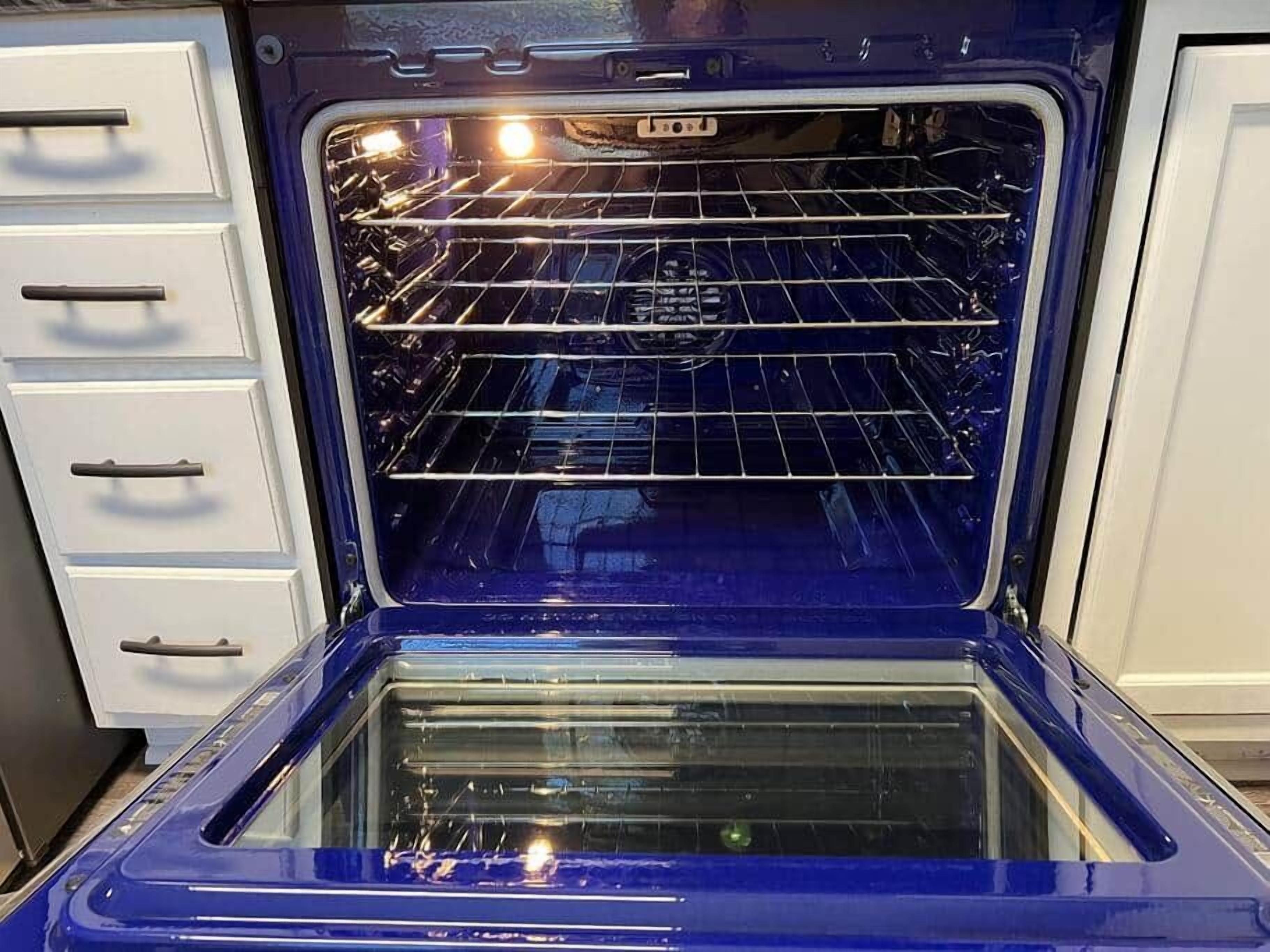 Un four ouvert avec une grille métallique à l’intérieur.