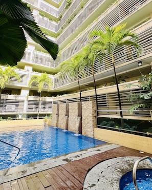 A multi-level swimming pool with surrounding balconies and greenery. - HENRY & ADICHE  EMPERADOR BUILDING (Pasay)