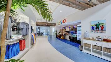 A clothing store with a blue carpet, wooden ceiling, and a juice bar.