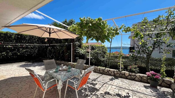 An outdoor patio with a table and chairs, a pergola with a canopy, and a view of the sea. - Holiday apartment with terrace and air conditioning (Dramalj)