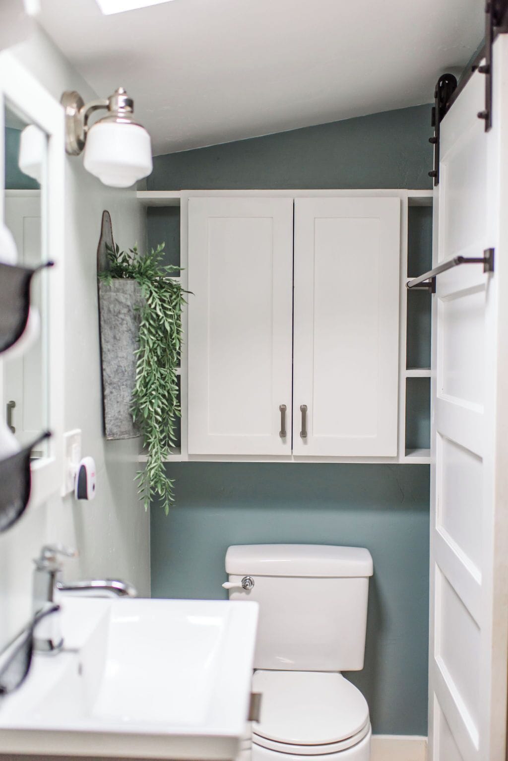 A bathroom with a white toilet, a sink, and a cabinet.