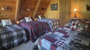 Un chalet confortable avec trois lits, des murs en bois et une décoration sur le thème des animaux.
