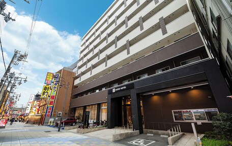 A hotel with multiple floors, a prominent entrance, and a parking area.