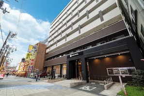 A hotel with multiple floors, a prominent entrance, and a parking area. - KOKO HOTEL Osaka Shinsekai (Osaka)