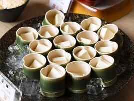 Un plato con vasos verdes, cubitos de hielo y bloques de tofu.