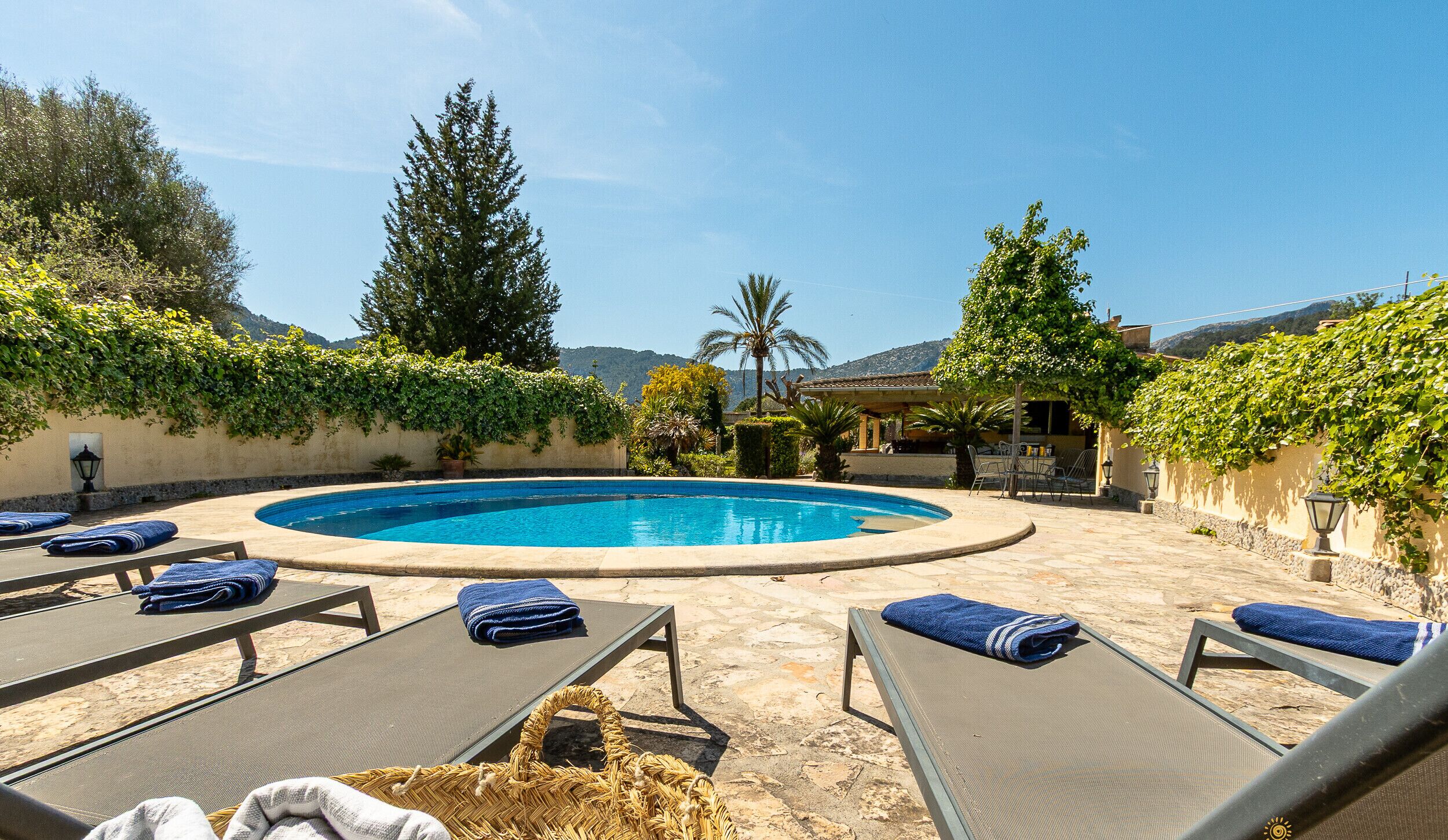 Un espace piscine avec des chaises longues et un panier en osier.