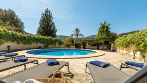 A pool area with lounge chairs and a wicker basket.