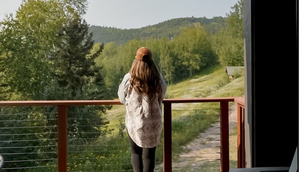 A person standing on a balcony overlooking a forested hillside. - Whirlpool Suite w/ Pool, Hot Tub, Hiking, Golfing, & More on Lutsen Mountain (Tofte)