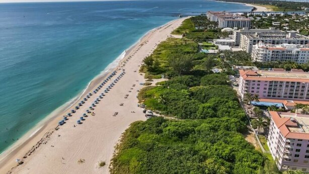 A coastal hotel with a beach, multiple buildings, and a clear view of the ocean. - Spacious one-bedroom beach apartment on Singer Island (Palm Beach Shores)
