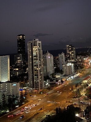 A nighttime cityscape with high-rise buildings and busy streets.