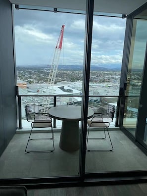 Enjoy a view of the surrounding area from the balcony with a table and chairs.