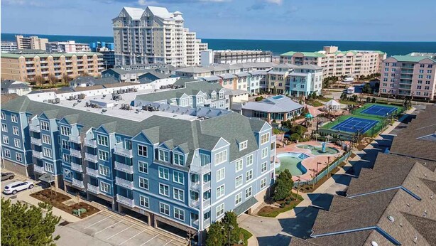 A multi-story hotel with a rooftop pool and tennis courts.