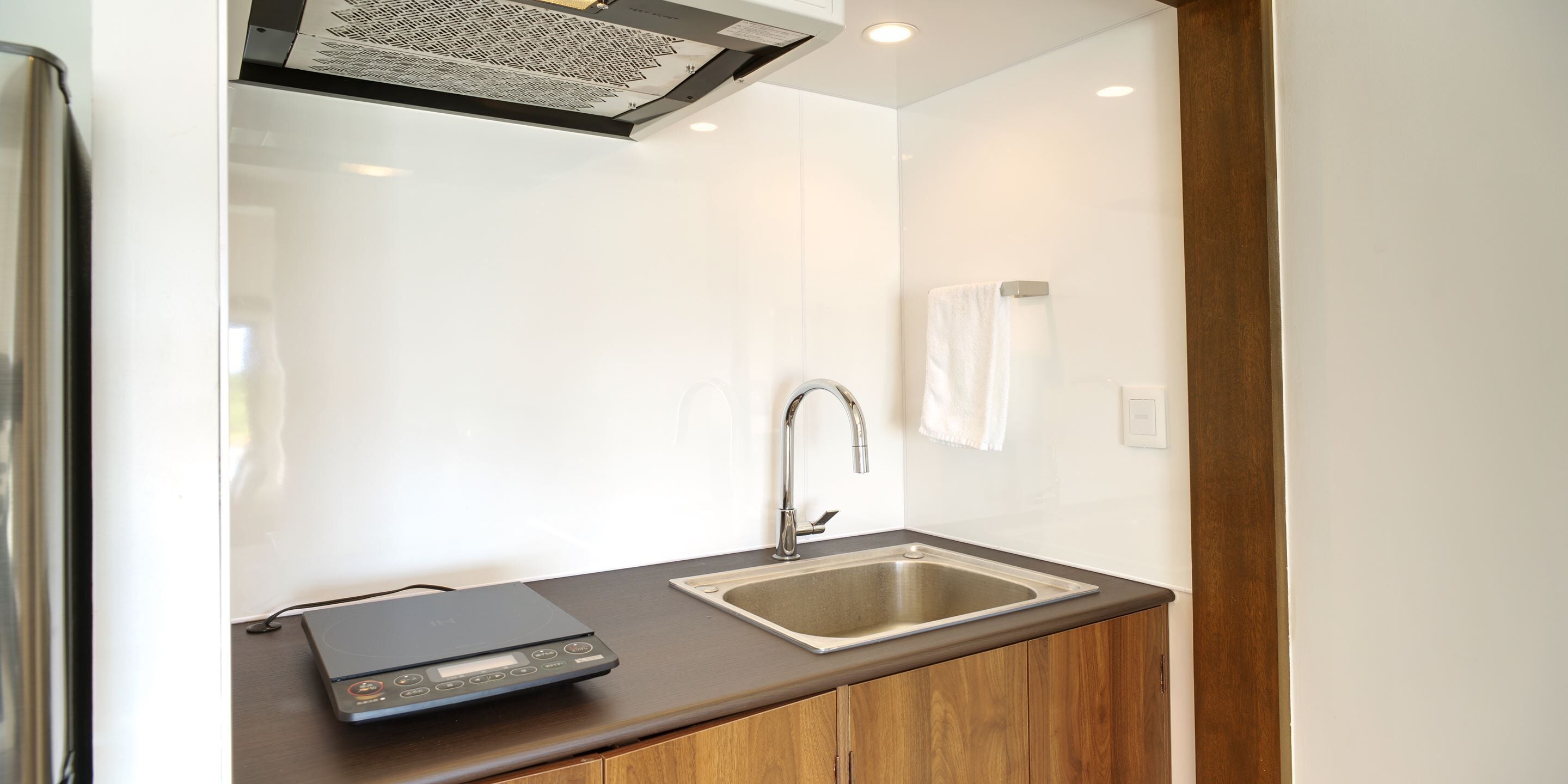 A modern kitchen with a built-in sink, a digital scale, and a stainless steel faucet.
