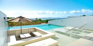 A modern outdoor pool area with lounge chairs and a sun umbrella, overlooking a scenic ocean view. - ADANRESORT LANA Villa Suite (Motobu)