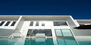 A modern building with a pool, white exterior, and large windows. - ADANRESORT LANA Villa Suite (Motobu)