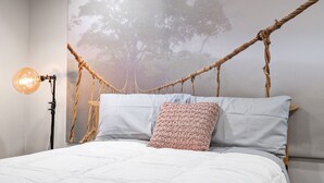 A bed with a rope headboard, a hanging light fixture, and a wall mural. - Luxurious home with golf course view, deck, grill, Peloton! King size bed.  (Fairfax)