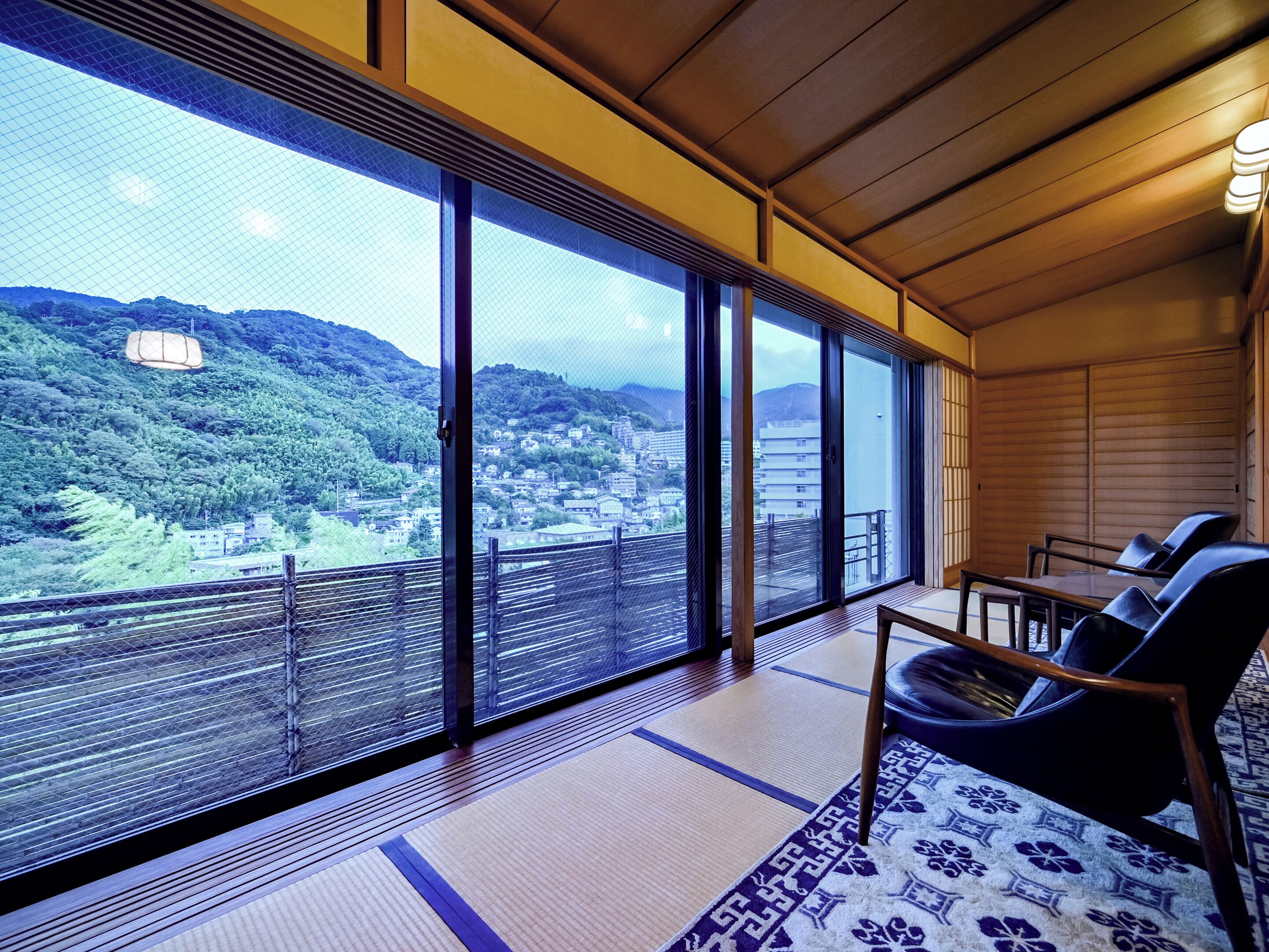 Una habitación con esteras de tatami, una mesa baja y sillas.