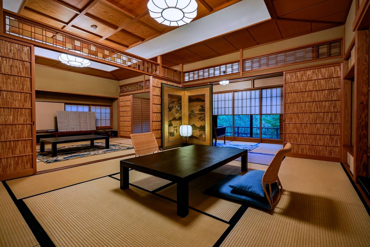 A traditional Japanese room with tatami flooring, a low table, and sliding doors.