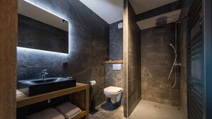 Une salle de bain moderne avec une douche à parois de verre, un meuble-lavabo en bois et des toilettes.