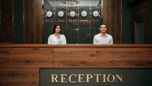 A reception desk with clocks displaying times from New York, London, Moscow, Urgenc, and Tokyo. - FAYZ HOTEL (Urgench)