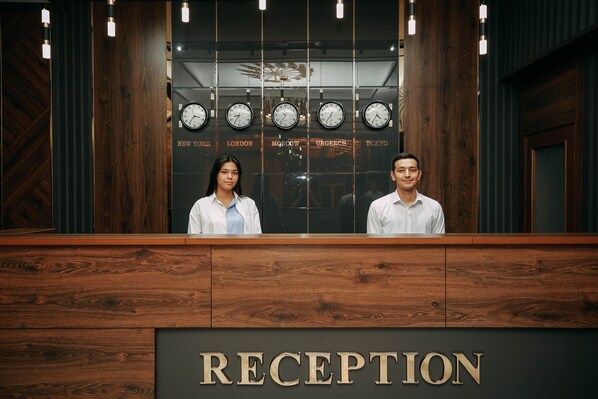 A reception desk with clocks displaying times from New York, London, Moscow, Urgenc, and Tokyo.