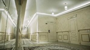 A corridor with a mirrored wall, a carpeted floor, and a door labeled "404". - FAYZ HOTEL (Urgench)