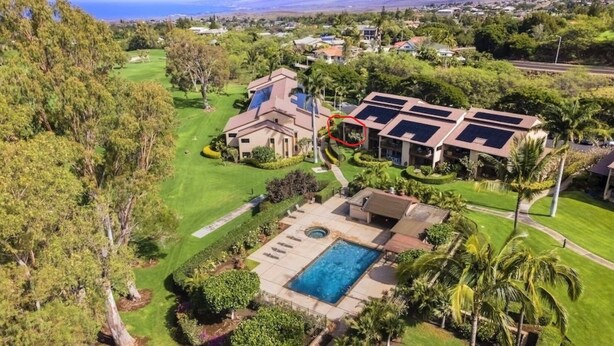 Ein Wohnhaus mit Swimmingpool, Solaranlage und Golfplatz im Hintergrund.