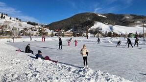 Un paysage enneigé avec une piste de ski, des bâtiments et une montagne en arrière-plan.