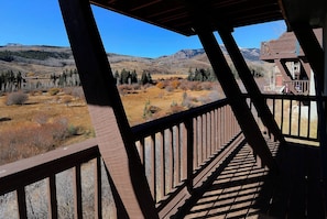 Une terrasse en bois offrant une vue sur un paysage montagneux.