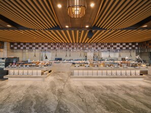 Una cafetería moderna y espaciosa con un mostrador central, varias zonas de estar y un diseño de techo de madera.