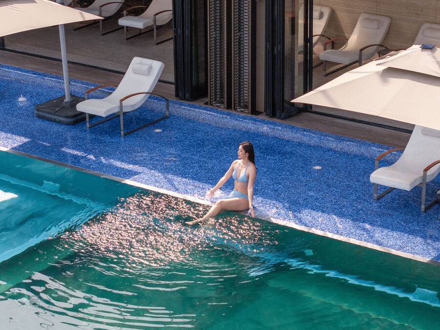 A pool area with lounge chairs and umbrellas.