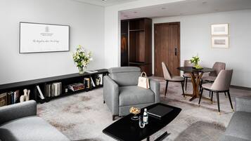 Una sala de estar moderna con un sofá gris, una mesa de centro negra y una estantería con libros y objetos decorativos.