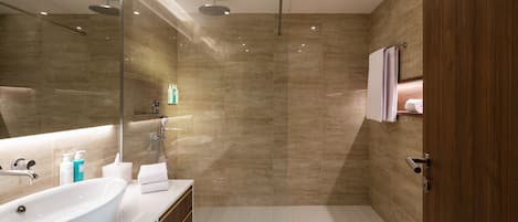Une salle de bain moderne avec un grand lavabo, un miroir et une douche.