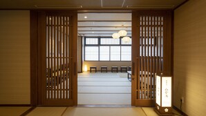 A traditional Japanese room with tatami flooring, sliding doors, and a shoji screen.