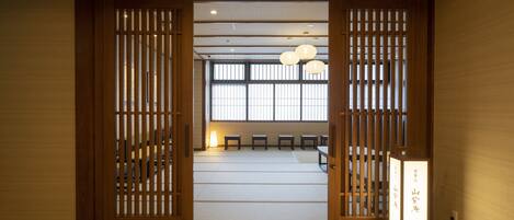 A traditional Japanese room with tatami flooring, sliding doors, and a shoji screen.
