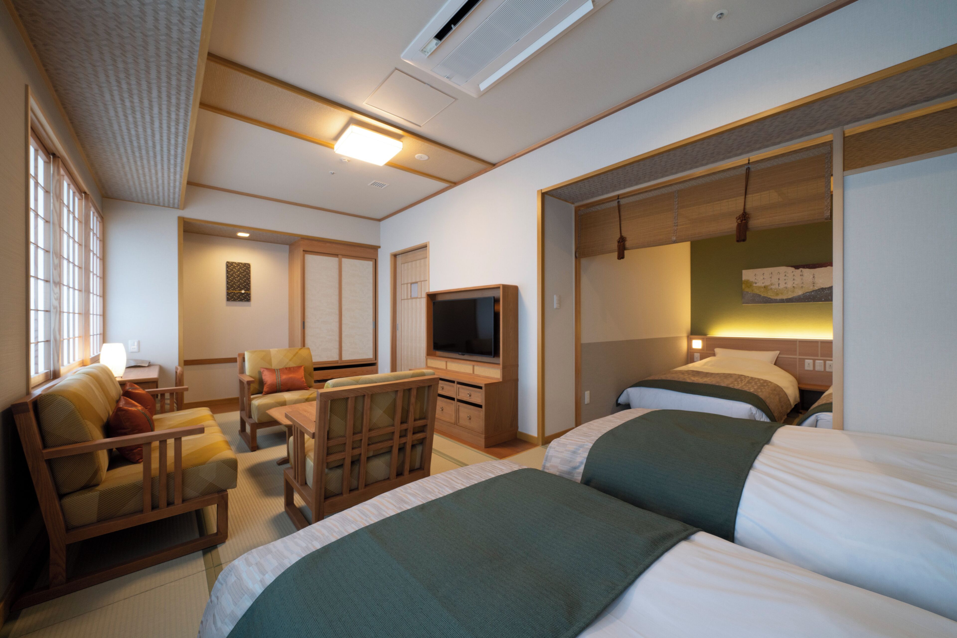 A hotel room with a bed, a TV, a desk, and a chair.
