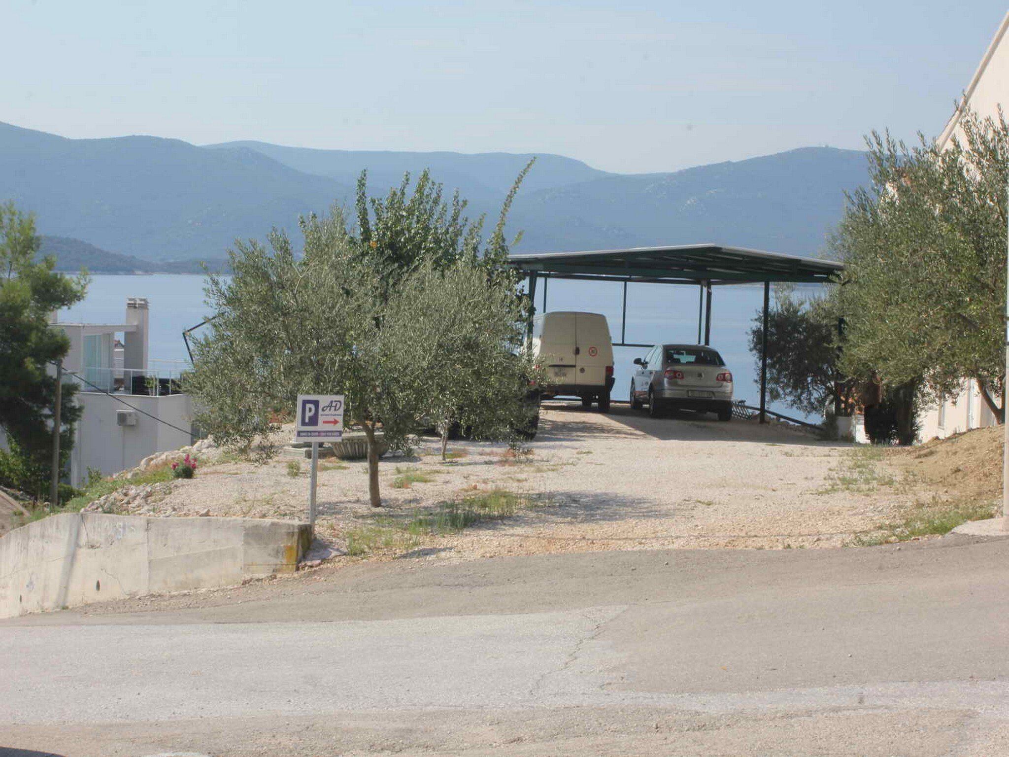 Un espace de stationnement doté d’un abri couvert, d’un fourgon et d’une voiture.