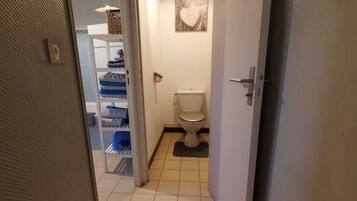 Een bad/douchecombinatie, een haardroger, handdoeken, zeep