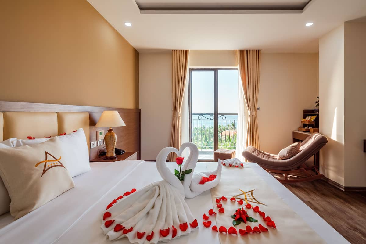 Een hotelkamer met een bed, een massagestoel, een raam met gordijnen en uitzicht op de omgeving.