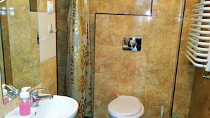 A bathroom with a white sink, a toilet, and a shower curtain. - HOSTEL OMEGA (Rzeszów)