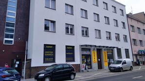 A multi-story building with several windows and a signboard for a hostel. - HOSTEL OMEGA (Rzeszów)