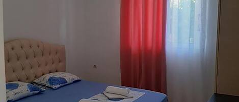 A bedroom with a bed, a bedside table, and a wardrobe.