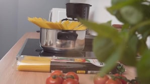 A kitchen counter with uncooked spaghetti, a pot, and a box of pasta. - LaOla Living - Hostel (Essen)