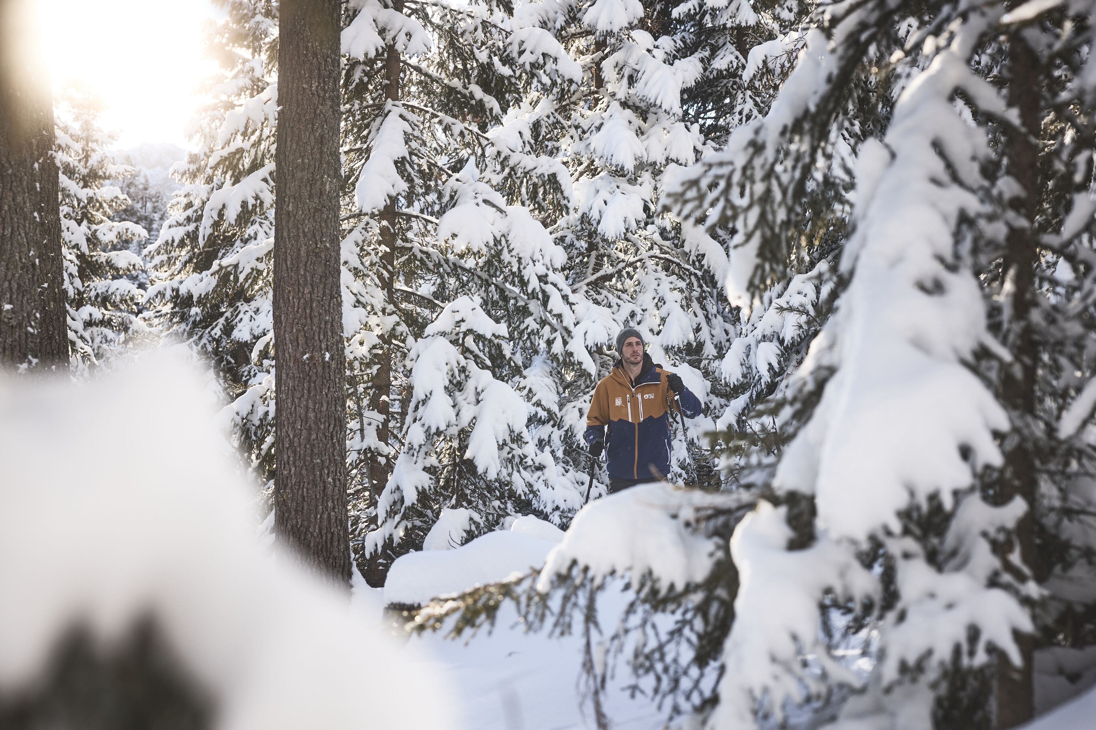 Eine Person steht in einem verschneiten Wald.