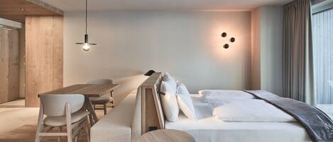 A modern bedroom with a wooden bed, a desk, and chairs.