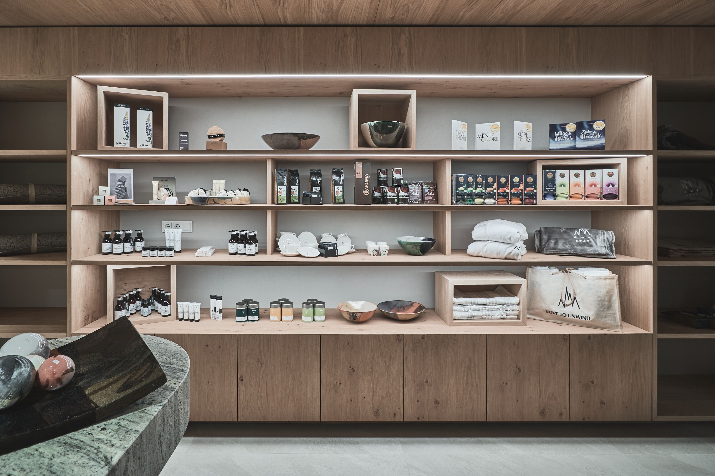A wooden shelving unit with various kitchenware and food items.