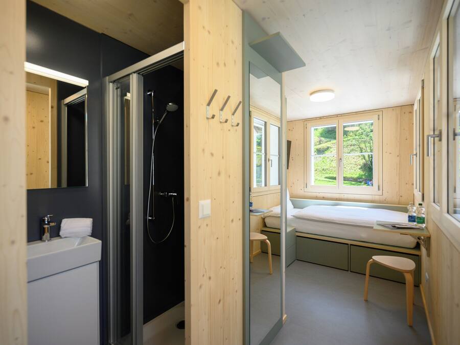 A modern bathroom with a shower, sink, and mirror.
